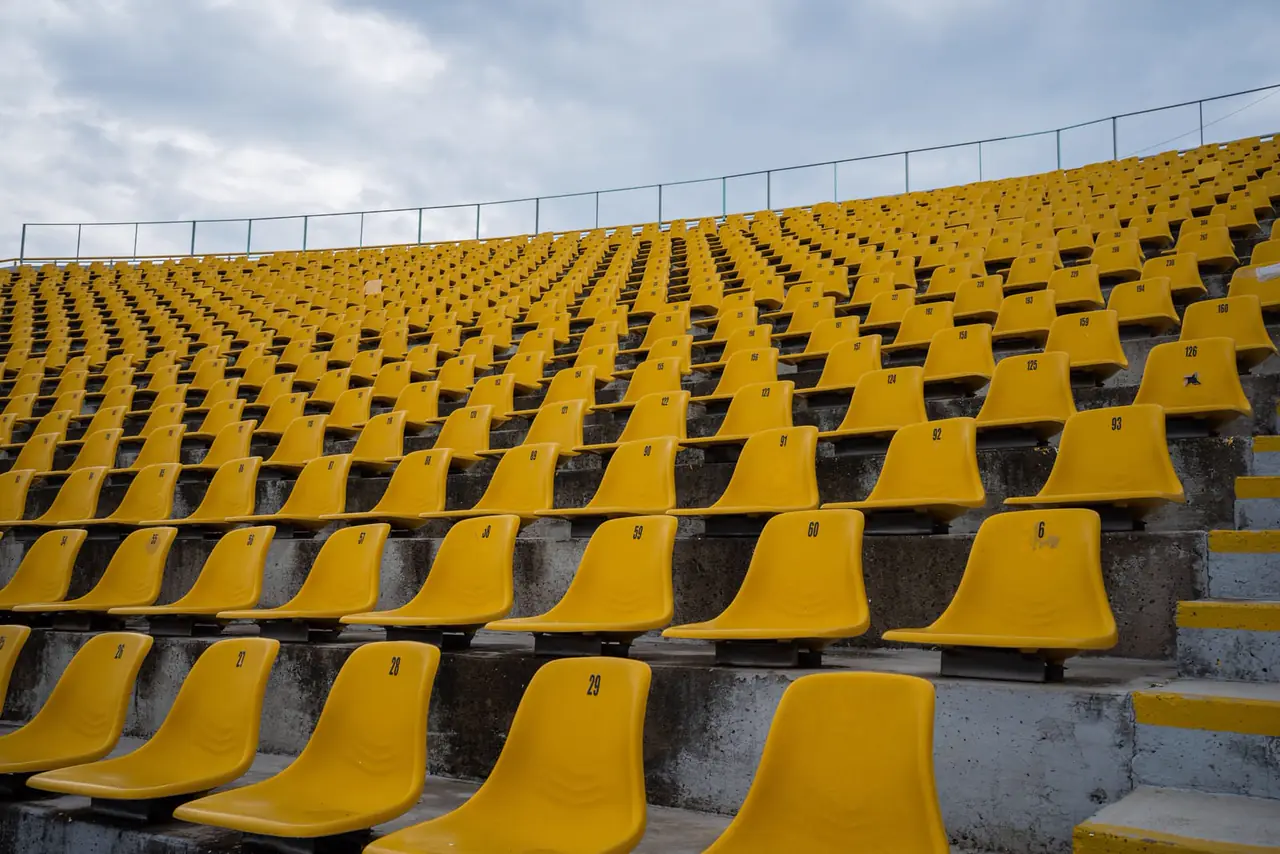 An empty ballpark at dusk under stadium lights.